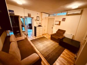 a living room with a couch and a chair at Center House Hostel in Prishtinë