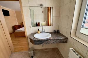 a bathroom with a sink and a mirror at Ferienzimmer direkt am See in Priepert