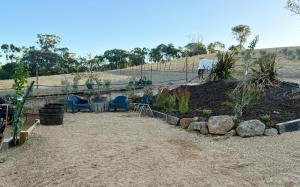 a garden with a table and chairs in a field at Hickey Vale Farm Studio in Broadford