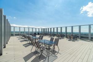 a deck with tables and chairs on a balcony at FRANKO APARTAMENTS - Hanza Tower in Szczecin
