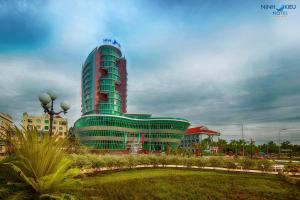 a large building with a green building at Ninh Kieu Riverside Hotel in Can Tho