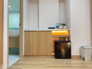 a kitchen with a counter with a sink and a refrigerator at Armass Residence in Bangna