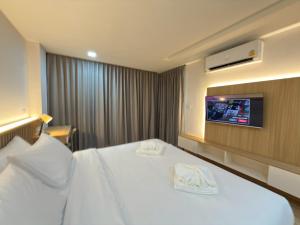 a hotel room with a bed and a tv at Armass Residence in Bangna