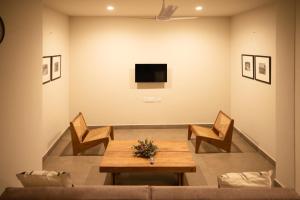 a living room with a table and chairs and a tv at Ara Ki Serviced Apartments in Kohīma +8 photos
