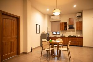 a kitchen with a table and chairs in a room at Ara Ki Serviced Apartments in Kohīma