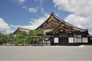 a building with a roof with trees in front of it at Hotel Gimmond Kyoto in Kyoto