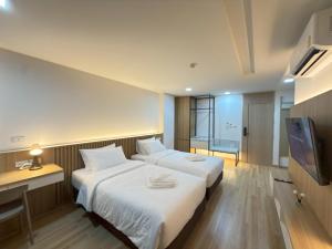 a hotel room with two beds and a television at Armass Residence in Bangna