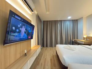 a hotel room with a bed and a flat screen tv at Armass Residence in Bangna +70 photos