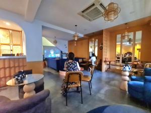 a woman sitting at a table in a living room at Myths Saigon in Ho Chi Minh City