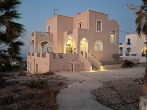 a large white house with a palm tree at Villa Anna with Panoramic sea views in Pyrgos