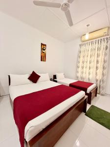 a bedroom with two beds and a ceiling fan at Bon Voyaage Tourist Inn in Trincomalee