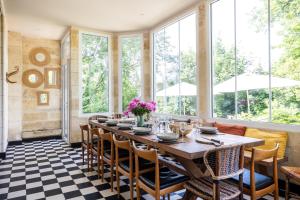a dining room with a table and chairs and windows at chalet baron in Lormont