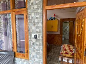 a room with a door and a window and a chair at Kingdom Homestays in Manāli