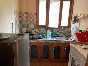 a kitchen with a sink and a counter top at Kingdom Homestays in Manāli