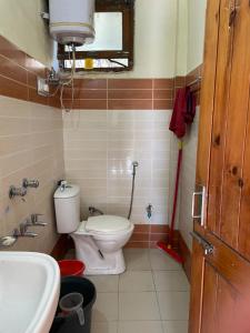 a small bathroom with a toilet and a sink at Kingdom Homestays in Manāli