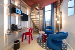 a room with red and blue chairs and a staircase at City Hotel Rembrandt Square - Just renovated in Amsterdam
