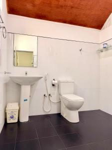 a bathroom with a toilet and a sink at Bon Voyaage Tourist Inn in Trincomalee +27 photos