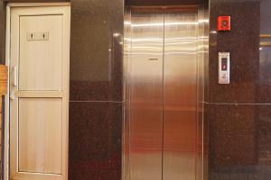 a metal elevator next to a white door at OYO 839 Hotel Middle Temple in Kathmandu +13 photos