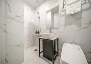 a white bathroom with a sink and a toilet at No25 Doksan Intersection in Seoul