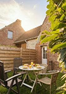 a patio with a table and chairs with food on it at La Maisonnette - 2 chambres, parking, jardinet & calme in Tournai