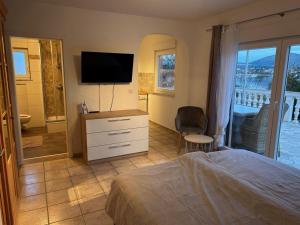 a bedroom with a bed and a television on a dresser at Villa Nikki in Bilice