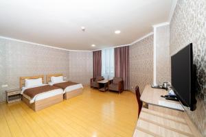 a hotel room with a bed and a flat screen tv at Inga Hotel Yerevan in Yerevan