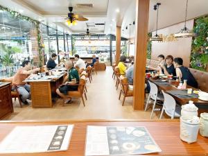 a group of people sitting at tables in a restaurant at Win Hotel Vang Vieng in Vang Vieng