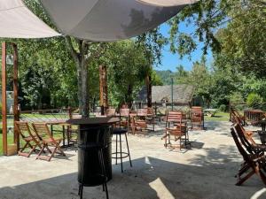 a group of tables and chairs under an umbrella at Gites et camping le Sédour in Riom-ès-Montagnes