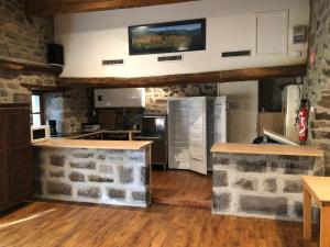 a kitchen with stone walls and a counter top at Gites et camping le Sédour in Riom-ès-Montagnes