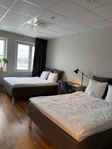 a hotel room with two beds and a couch at Hotell Fyrislund in Uppsala