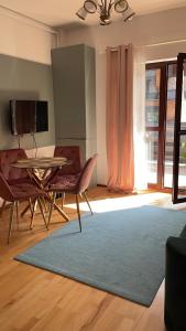a living room with a table and chairs and a rug at Apartament Stanca Piticului in Sinaia