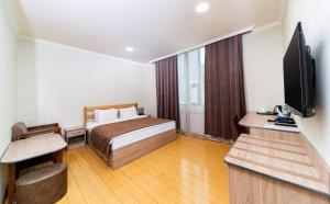a hotel room with a bed and a flat screen tv at Inga Hotel Yerevan in Yerevan +29 photos