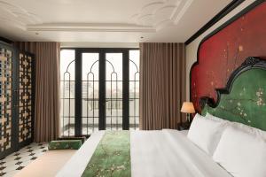 a bedroom with a large bed and a large window at C'Lau Hotel Ninh Binh - A Gem Nestled in Ancient Quarter in Ninh Binh