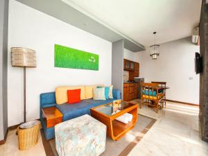 a living room with a blue couch and a table at Seminyak Icon - by Karaniya Experience - CHSE certified in Seminyak