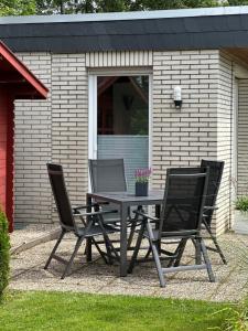 a table and four chairs in front of a house at Ferienhaus Wattglück Tossens in Butjadingen
