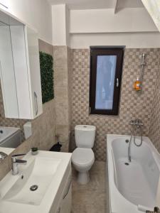 a bathroom with a toilet and a tub and a sink at studiou central in Târgu Jiu