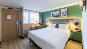 a hotel room with a large bed and a window at Campanile NATURE - Lyon Est Bron Eurexpo in Bron