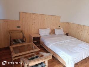a room with a bed and a table in it at The Holiday Resort in Kailāna