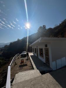 a car parked next to a building with the sun shining at The Holiday Resort in Kailāna