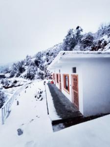 a white building with snow on the side of it at The Holiday Resort in Kailāna