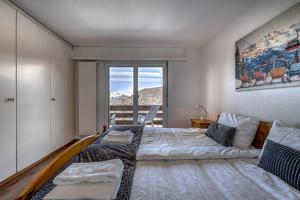 a bedroom with a large bed and a window at Appartement Tzoum'Azur 6 in La Tzoumaz