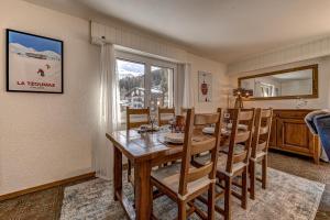 a dining room with a table and chairs and a window at Appartement Tzoum'Azur 6 in La Tzoumaz +17 photos