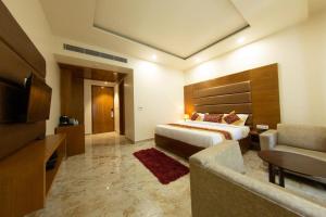 a hotel room with a bed and a couch at Comfort By Choice in Amritsar