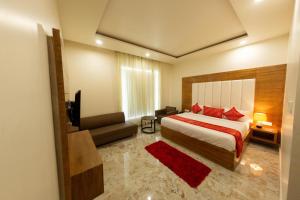 a bedroom with a bed and a couch and a television at Comfort By Choice in Amritsar +4 photos