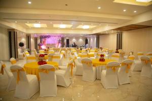 a banquet hall with yellow and white tables and chairs at Comfort By Choice in Amritsar
