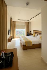a hotel room with a bed and a large window at Comfort By Choice in Amritsar