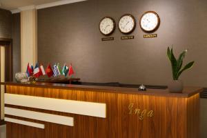 three clocks on the wall above a reception desk at Inga Hotel Yerevan in Yerevan