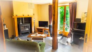 a living room with a couch and a fireplace at Les 3 pruniers in Cieux