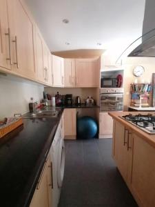a kitchen with white cabinets and a black counter top at Les 3 pruniers in Cieux
