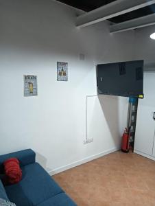 a living room with a blue couch and a flat screen tv at A Casa di MaPe in Viterbo